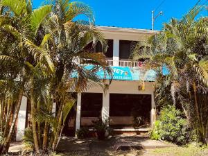 a white building with palm trees in front of it at Casa Mia in Sámara