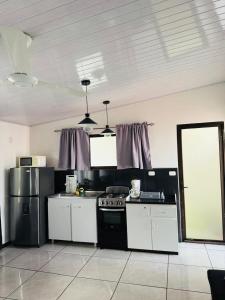a kitchen with white cabinets and a black stove at Casa Mia in Sámara +11 photos
