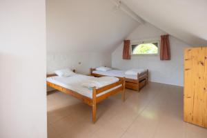 a bedroom with two beds and a window at CAMPING LE SAILLET Lestelle Betharram in Lestelle-Bétharram