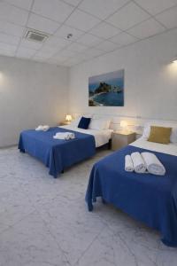 two beds in a room with blue sheets at ROOMS alCentro in Catania +28 photos