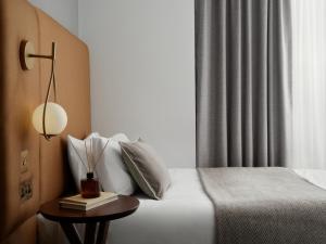 a bedroom with a bed and a table with a lamp at Bob W London Hyde Park in London