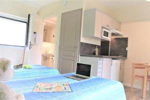 a room with two beds and a laptop on a bed at ZEcamping 3 étoiles pet friendly animations piscine chauffée in Merdrignac