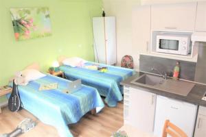 a small kitchen with two beds and a sink at ZEcamping 3 étoiles pet friendly animations piscine chauffée in Merdrignac