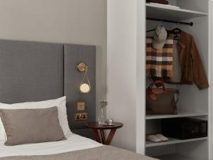 a bedroom with a bed and a table and a closet at Bob W London Hyde Park in London