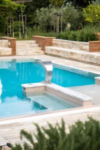 a swimming pool in a yard with blue water at Appartamenti Villa La Fonte in San Gimignano