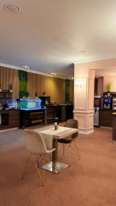a living room with a table and two chairs at Astoria Hotel & SPA in Hunedoara