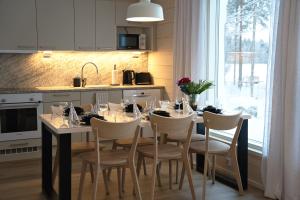 a kitchen with a table with chairs and a dining room at Villa Mustikkaranta Koli, oma ranta in Kolinkylä +23 photos