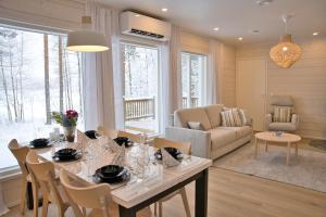 a dining room and living room with a table and chairs at Villa Mustikkaranta Koli, oma ranta in Kolinkylä