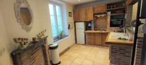a kitchen with a white refrigerator and a sink at Le haut clocher in Fumay