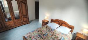 a bedroom with a bed with a dresser and a mirror at Le haut clocher in Fumay