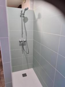 a bathroom with a shower with blue tiles at Le haut clocher in Fumay +8 photos