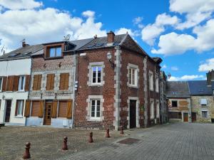 an old brick building on a cobblestone street at Le haut clocher in Fumay