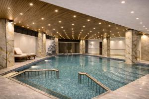 a large swimming pool in a building with lights at Hotel Materhorn in Kovalam