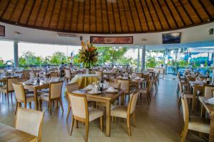 Hotel Florida Sinú في مونتيريا: مطعم بطاولات وكراسي خشبية ونوافذ