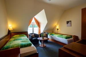 a hotel room with two beds and a window at ApartOne Hotel Brückenschänke in Sebnitz