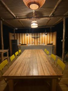 a large wooden table in a room with yellow chairs at I Semplici Rural Glamping in Mercato San Severino