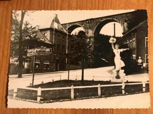 an old photo of a woman jumping over a fence at ApartOne Hotel Brückenschänke in Sebnitz