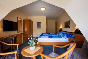 a hotel room with a bed and a table and chairs at ApartOne Hotel Brückenschänke in Sebnitz