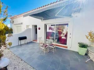 a patio with a table and chairs in front of a house at Location Luccini in Saintes-Maries-de-la-Mer