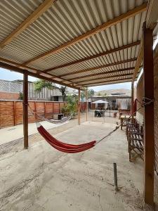 a hammock in a patio with a roof at Vista Palmeras in Zorritos