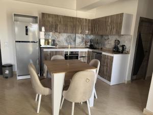 a kitchen with a table and chairs and a refrigerator at Sea-View 1BR Apartment Balcony Full Kitchen Resort in Marsa Alam City