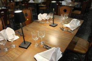 a long wooden table with wine glasses and napkins at Pisani Hotel in San Nicola La Strada