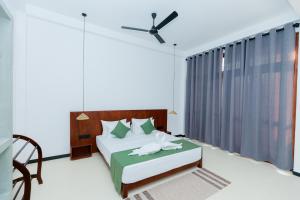 a bedroom with a bed and a ceiling fan at KIRI's HEAVEN in Ahangama