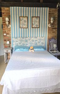 a teddy bear sitting on top of a bed at La Petite France in Nova Petrópolis