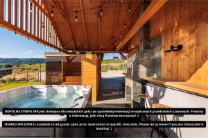a hot tub on the patio of a house at Stylchyn Park - Czorsztyn Exclusive - by Upstairs in Kluszkowce