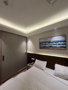 a bedroom with a bed and a painting on the wall at The Sterling Aroma in Greater Noida