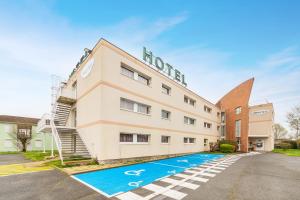 a hotel with a swimming pool in front of it at Mister Bed Chambray Les Tours in Chambray-lès-Tours