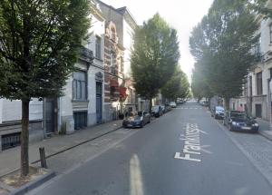 an empty street with cars parked on the side of the road at European Lodge Rooms Brussels in Brussels