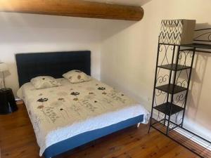 a bedroom with a bed with a black head board at Location Luccini in Saintes-Maries-de-la-Mer