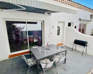a patio with a table and chairs on a balcony at Location Luccini in Saintes-Maries-de-la-Mer