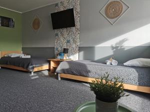 a hotel room with two beds and a flat screen tv at Gościniec nad Olzą in Cieszyn