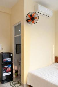 a bedroom with a bed and a fan on the wall at Tâm Quỳnh Motel in Vung Tau