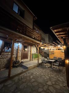 a patio with a table and chairs at night at Mountain Whisper Guesthouse in Smolyan