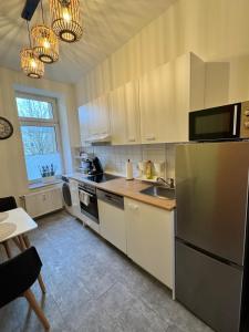 a kitchen with a stainless steel refrigerator and a sink at Arminos Large Group Apartment- 3 Zimmer & 2 WCs in Chemnitz