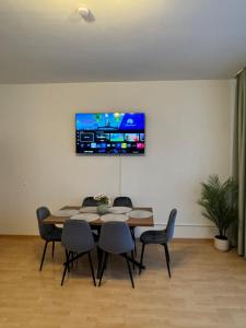 a dining room table with chairs and a tv on the wall at Arminos Large Group Apartment- 3 Zimmer & 2 WCs in Chemnitz