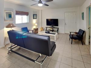 a living room with a couch and a tv at Paradise Retreat in Port Aransas