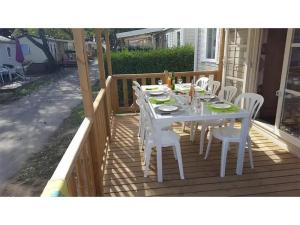 a white table and chairs on a deck at Chalet 4 étoiles - Piscine - ef0c00 in Monceaux-sur-Dordogne