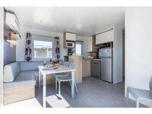 a kitchen and a living room with a table in a room at Chalet 4 étoiles - Piscine - ef0c00 in Monceaux-sur-Dordogne