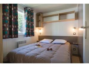 a large bed in a room with a window at Chalet 4 étoiles - Piscine - ef0c00 in Monceaux-sur-Dordogne