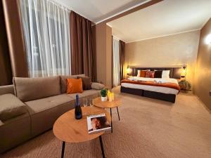 ein Wohnzimmer mit Sofa und Bett in der Unterkunft Hotel NIRÁ in Sofia