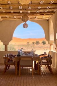 a table in a room with a view of the desert at Hotel Sunset Palace Merzouga in Merzouga