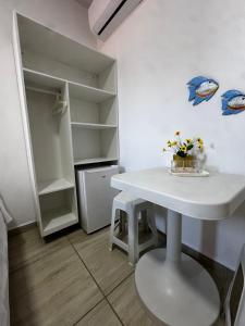 a small kitchen with a white table and a refrigerator at Pousada Maragobeach Suits in Maragogi