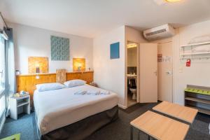 a hotel room with a bed and a table at Escale Kennedy in Mérignac +89 photos
