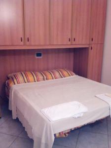 カストロヴィッラリにあるTra Gli Uliviの木製キャビネット付きのドミトリールームのベッド1台分です。