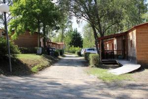 a house with a car parked next to a street at ZEcamping 3 dog friendly avec piscine au bord du lac de la Thésauque in Nailloux