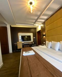 a hotel room with a large bed and a television at Presken Hotel White House, Lekki, Lagos in Lagos